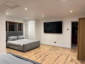 a bedroom with a bed and a flat screen tv at Broadway Pool House with Sauna & Jacuzzi in Herne Bay