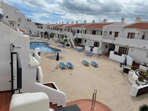 a courtyard with a pool and chairs and buildings at Apartmán Vlasta in Arona