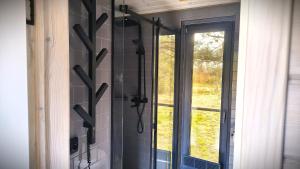 a glass shower in a bathroom with a window at Лісове SPA in Vishenki