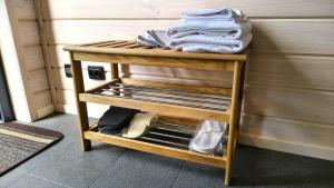 a small wooden shelf with folded towels on it at Лісове SPA in Vishenki