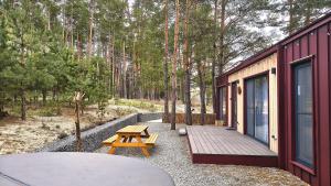 a cabin with a wooden deck and a picnic table at Лісове SPA in Vishenki