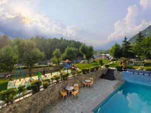 a resort with a swimming pool and a playground at The Allure Grand - Riverside Resort & Spa in Manāli