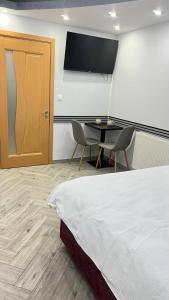 a bedroom with a bed and a table and a television at "Augustina" apartment in Topliţa