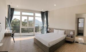 a bedroom with a bed and a large window at Lan Anh Villas Resort in Da Lat