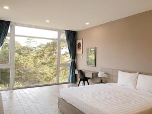 a bedroom with a bed and a large window at Lan Anh Villas Resort in Da Lat