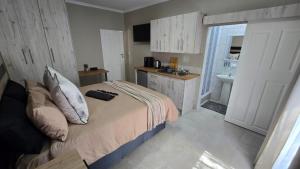 a bedroom with a bed and a bathroom with a sink at Waverley Rest in Bloemfontein