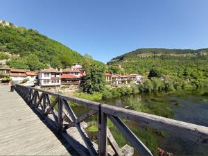 a bridge over a river with houses on a hill at Apart Tsarevets View - Free PARKING in Veliko Tŭrnovo
