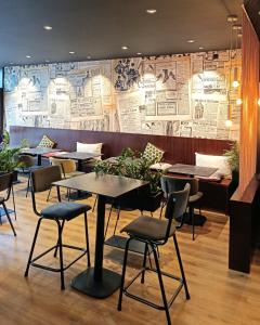 a restaurant with tables and chairs and posters on the wall at Lorient Résidence in Caudan