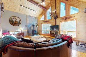 a living room with a large leather couch in a cabin at Rivercrest in South Fork