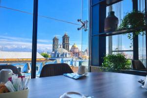 a table in an office with a view of the city at Hotel Tamara in Puebla