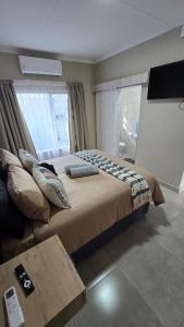 a bedroom with a large bed and a television at Waverley Rest in Bloemfontein