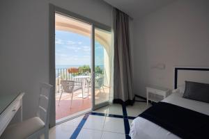 a bedroom with a bed and a balcony with a view at San Francesco Amalfi Coast Hotel in Maiori