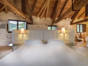 a bedroom with a large white bed with two lamps at Le Torri di Credazzo in Farra di Soligo
