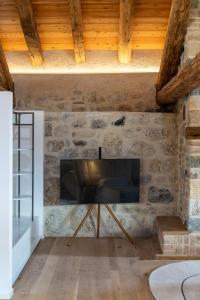 a living room with a television on a stone wall at Le Torri di Credazzo in Farra di Soligo