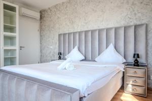 a bedroom with a large bed with white sheets at GT Loft - Haut de Gamme - Parking Gratuit - Moderne & Spacieux - Commerces à Proximité in Bischheim