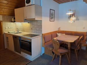 a kitchen with a table and a sink and a table and chairs at Zoberhof - Ferienhof zum Zoberbauer in Oberammergau +11 photos