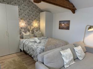 a bedroom with a bed and a couch at Petite Merveille sous les toits - Centre de Dijon in Dijon