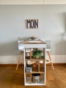 a small table with two chairs and a sign on a wall at Fewo GüNi Ostseeblick Wendtorf Marina Strand in Wendtorf