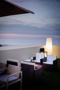 a room with chairs and a table and a lamp at Hotel Alexander in Riccione