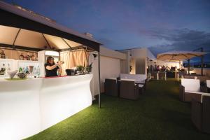 a woman standing at a bar in a building at Hotel Alexander in Riccione +23 photos