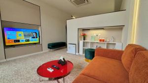 a living room with a couch and a flat screen tv at هدوء المنتهى in Al Munayzilah