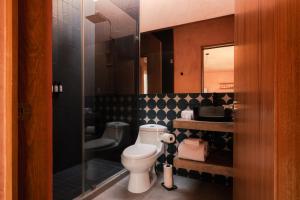 a bathroom with a toilet and a glass shower at Casa Maja Villas Chapala in Chapala +18 photos