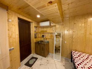 a room with wooden walls and a kitchen with a door at Nato & Lado in Sighnaghi