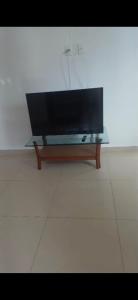 a flat screen tv sitting on top of a table at Aconchego perto da praia in Aracaju