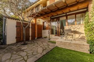 a patio with a table and a chair next to a house at Ventimiglia Garden Suite in Olbia