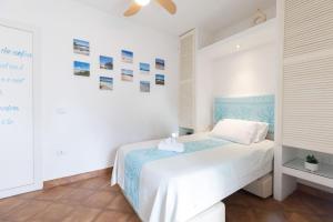 a white bedroom with a bed and a ceiling at Ventimiglia Garden Suite in Olbia