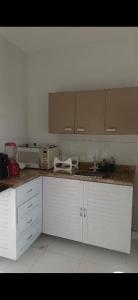 a kitchen with white cabinets and a microwave at Aconchego perto da praia in Aracaju