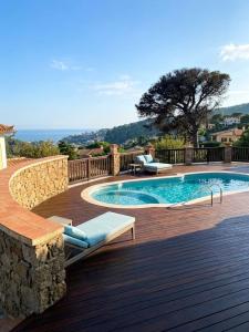 a swimming pool on a wooden deck next to a swimming poolvisor at Cave Luxury Villas Skiathos in Troulos