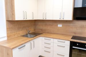 a kitchen with white cabinets and a sink at Edi Residence in Oplotnica +6 photos