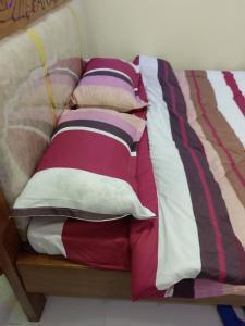 a bed with many pillows on top of it at Haven Breeze Villas in Nakuru