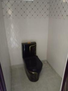 a bathroom with a black toilet in a room at Haven Breeze Villas in Nakuru