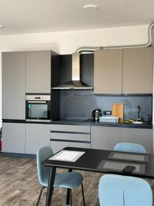 eine Küche mit einem Tisch und blauen Stühlen in der Unterkunft Manya in Seoca