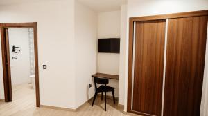 a room with a wooden closet and a chair in it at Hostal Central Marmolejo in Marmolejo