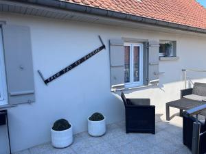 a white wall with two chairs and a table at le relais des étangs B in Mareuil-Caubert