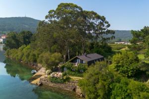 a house on the banks of a river at Cabanas da Auga in Ures