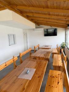 a large room with wooden tables and a flat screen tv at Бунгала ЛАГО in Gabrene