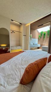 a large white bed with an orange pillow on it at هدوء المنتهى in Al Munayzilah +149 photos