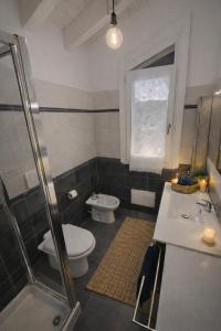 a bathroom with a toilet and a sink and a shower at Mansarda Polpetta in Corsico +5 photos