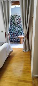 a bedroom with a bed with curtains and a wooden floor at a&bpikermistudios4 in Pikérmion