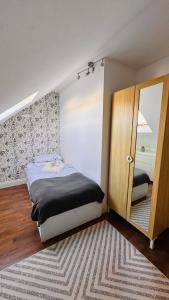 a small bedroom with a bed and a mirror at Broadway Apartment in London