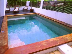 a pool with a wooden deck and a swimming pool at PIPA VILLA CAFE VERDE in Pipa