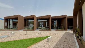 a building with a grass yard in front of it at هدوء المنتهى in Al Munayzilah