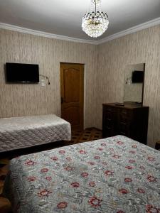 a hotel room with two beds and a chandelier at Tskaltubo Guesthouse Oda in Tsqaltubo