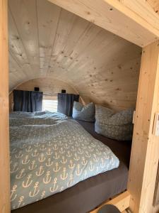 a bedroom in a log cabin with a bed in it at Schlaffass am Sund in Altefähr