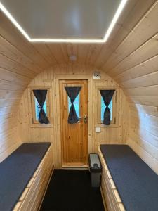 a small room with two beds in a wooden cabin at Schlaffass am Sund in Altefähr +8 photos