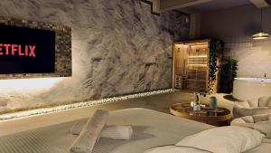 a room with a bed and a television and a tub at BREATH47SPA - Private Spa Suite White Jacuzzi & Sauna in Marbella in Marbella